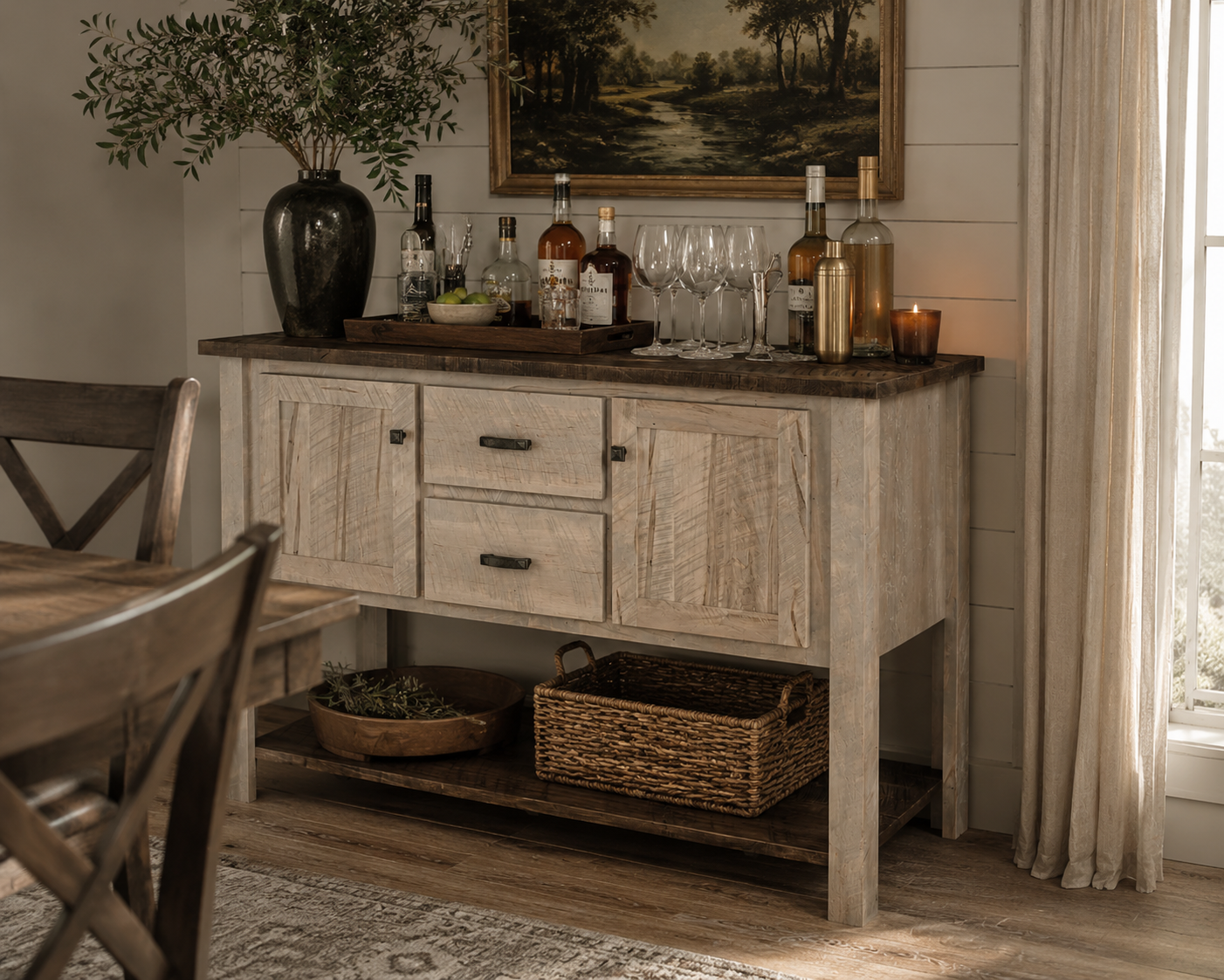 Rustic farmhouse dining room with a whitewashed buffet styled as a home bar, featuring glassware, spirits, and warm decor.