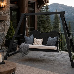 Weather proof black poly A-frame outdoor swing with neutral cushions on a luxury mountain patio overlooking forested peaks.