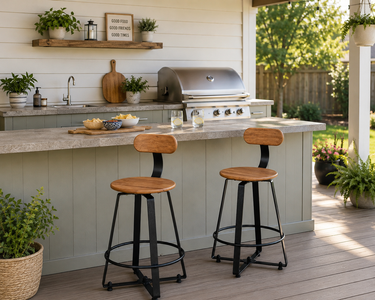 Outdoor swivel bar stools with wood-look seats and black metal frames at a backyard outdoor kitchen with a covered patio.