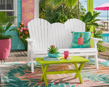 White poly outdoor loveseat and lime green coffee table on a tropical patio for colorful outdoor living