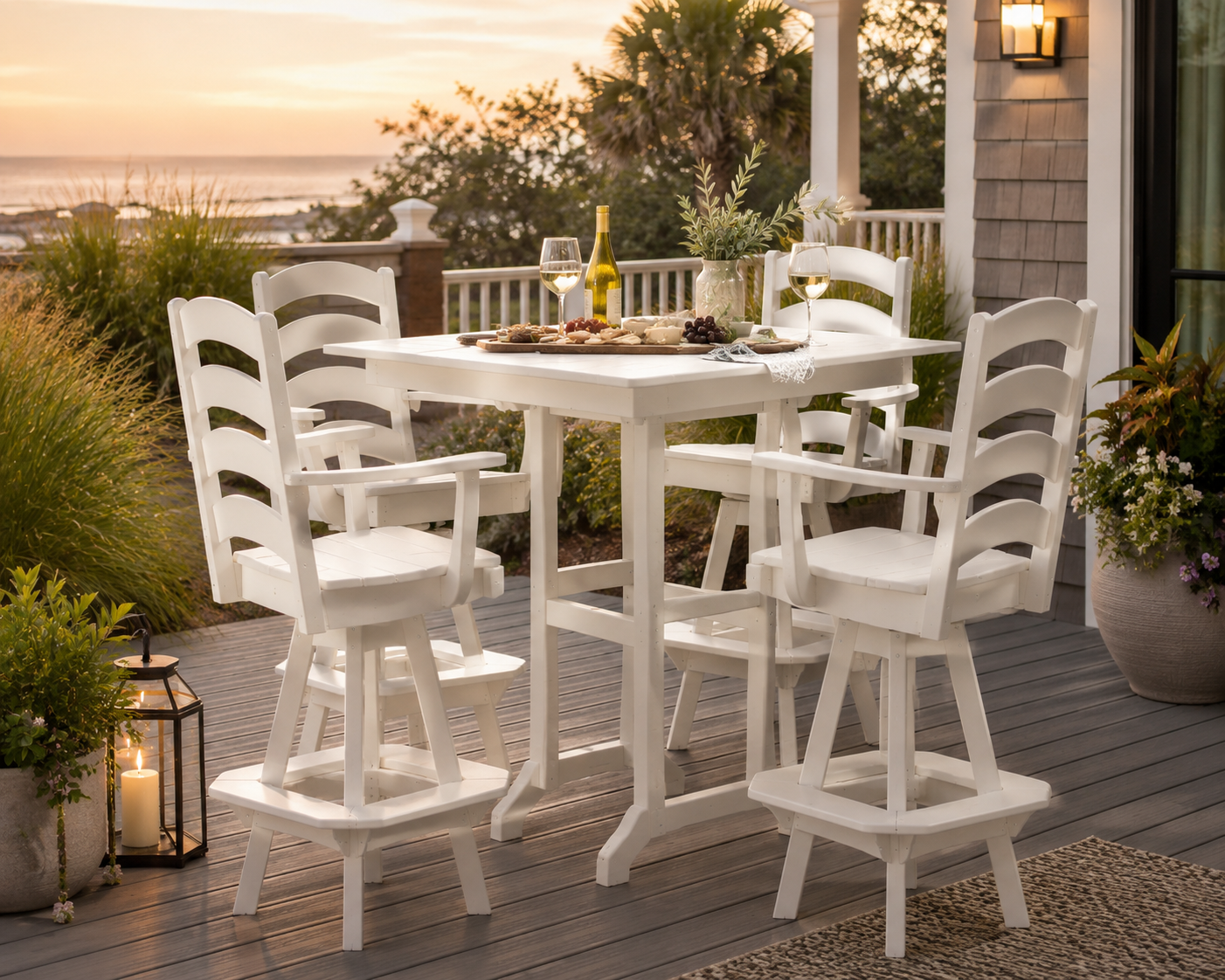 White poly swivel bar dining set on a coastal deck at sunset with wine, charcuterie, and ocean views.